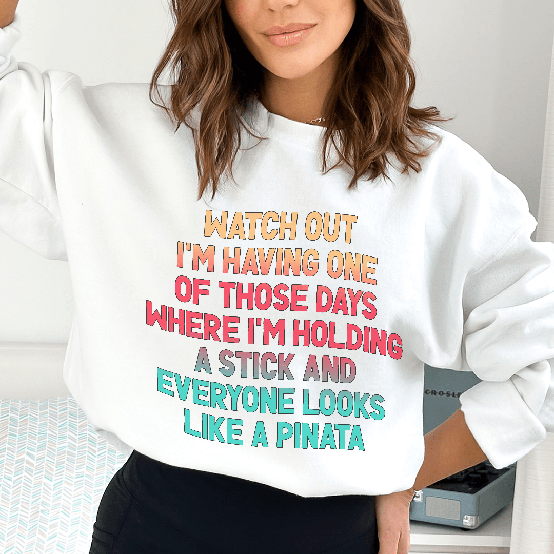 Merchmallow white sweatshirt with multicolor printed joke text worn by woman funny graphic sweatshirt