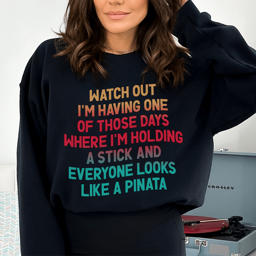 Merchmallow black funny graphic sweatshirt with multicolor bold text reading about holding a stick and pinata