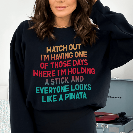 Merchmallow black funny graphic sweatshirt with multicolor bold text reading about holding a stick and pinata